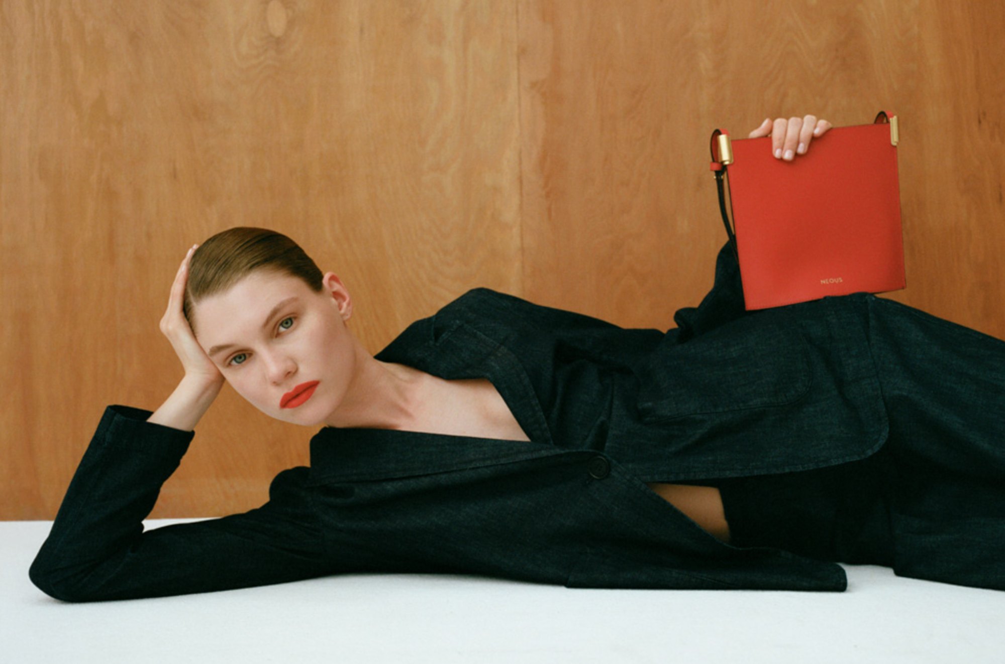 BABOCHKA — reclining figure in dark denim with a red bag
