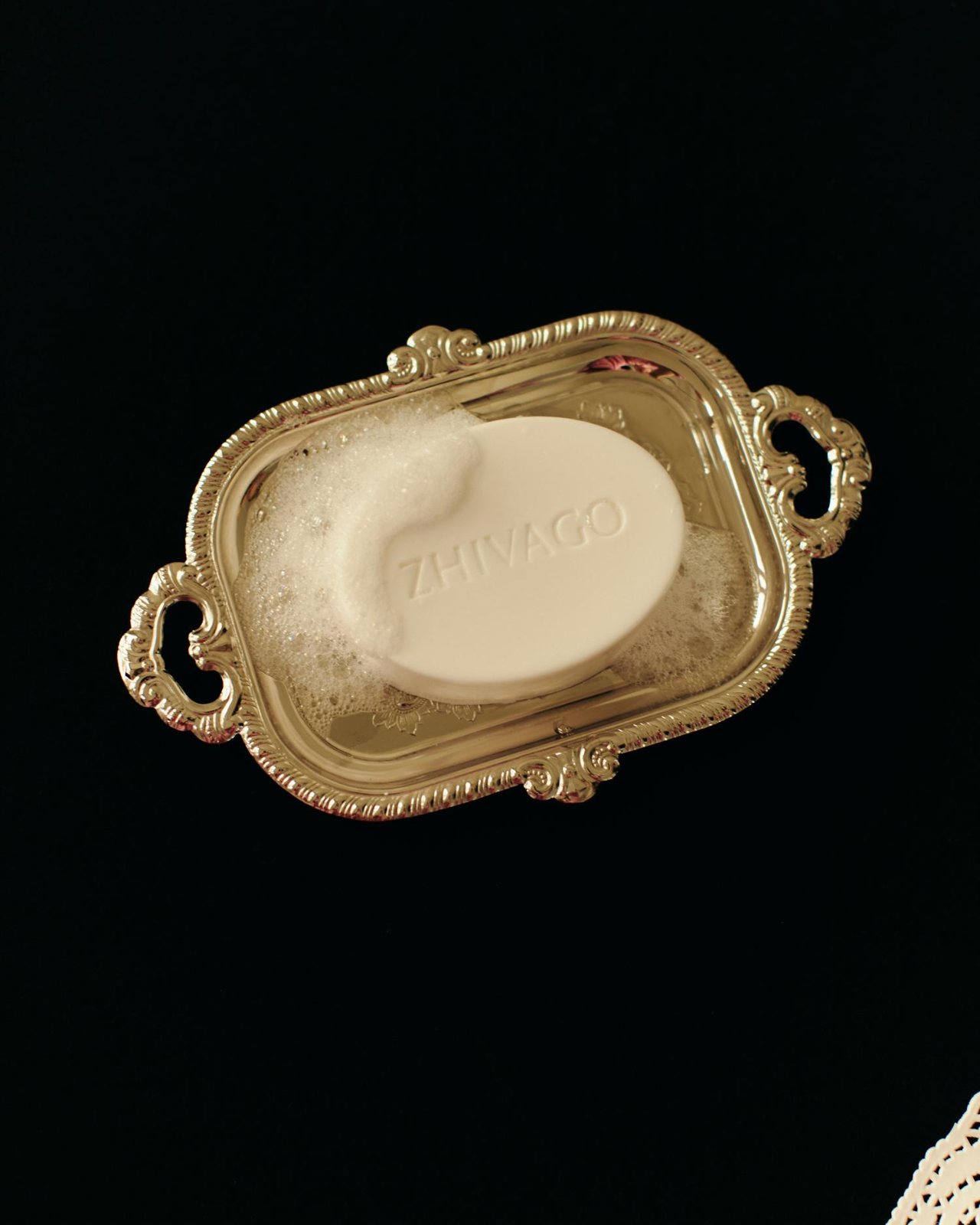 ZHIVAGO — embossed soap bar in foam on a silver tray against black