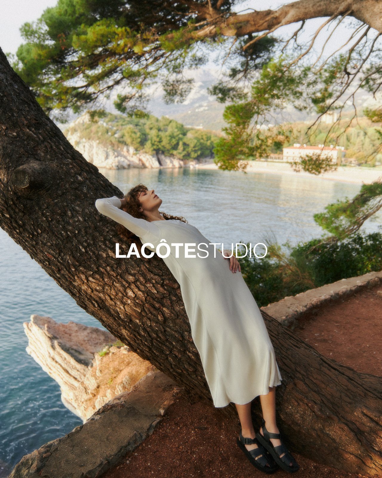 LA CÔTE — white dress against a pine over the bay