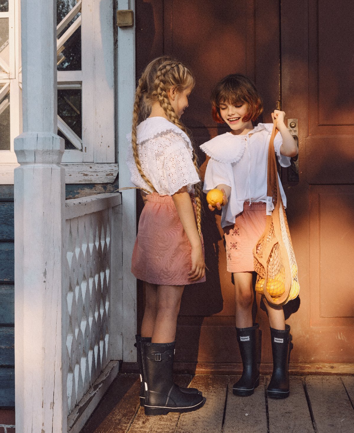 POLUSHA — campaign, two girls with a net bag of lemons in the evening light