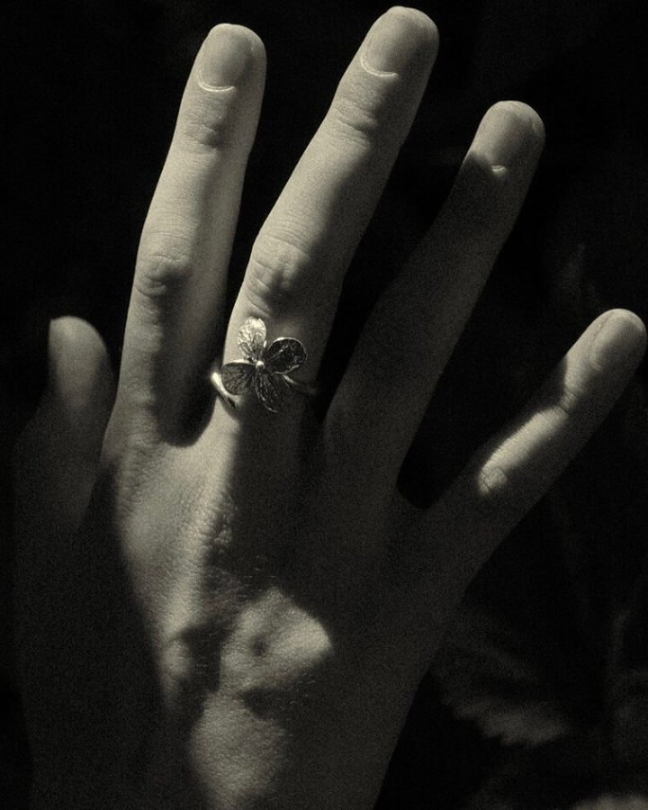 SHU SHA — hand with the flower ring against black